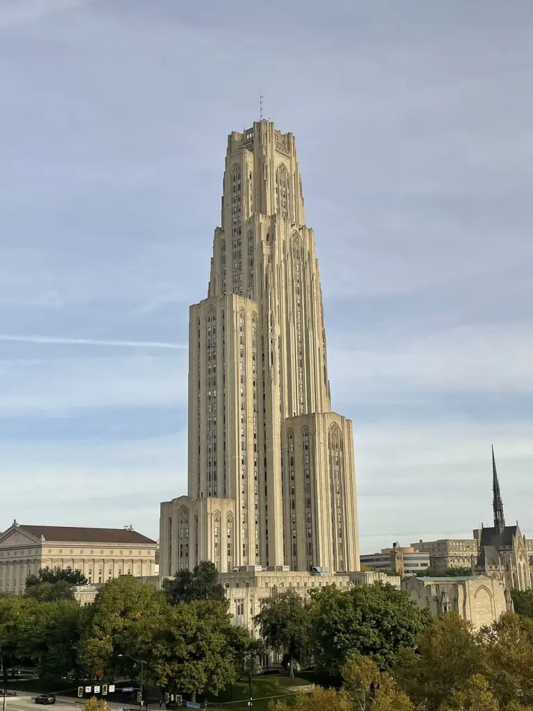 The Cathedral of Learning's Gothic tower rising above trees on the University of Pittsburgh campus