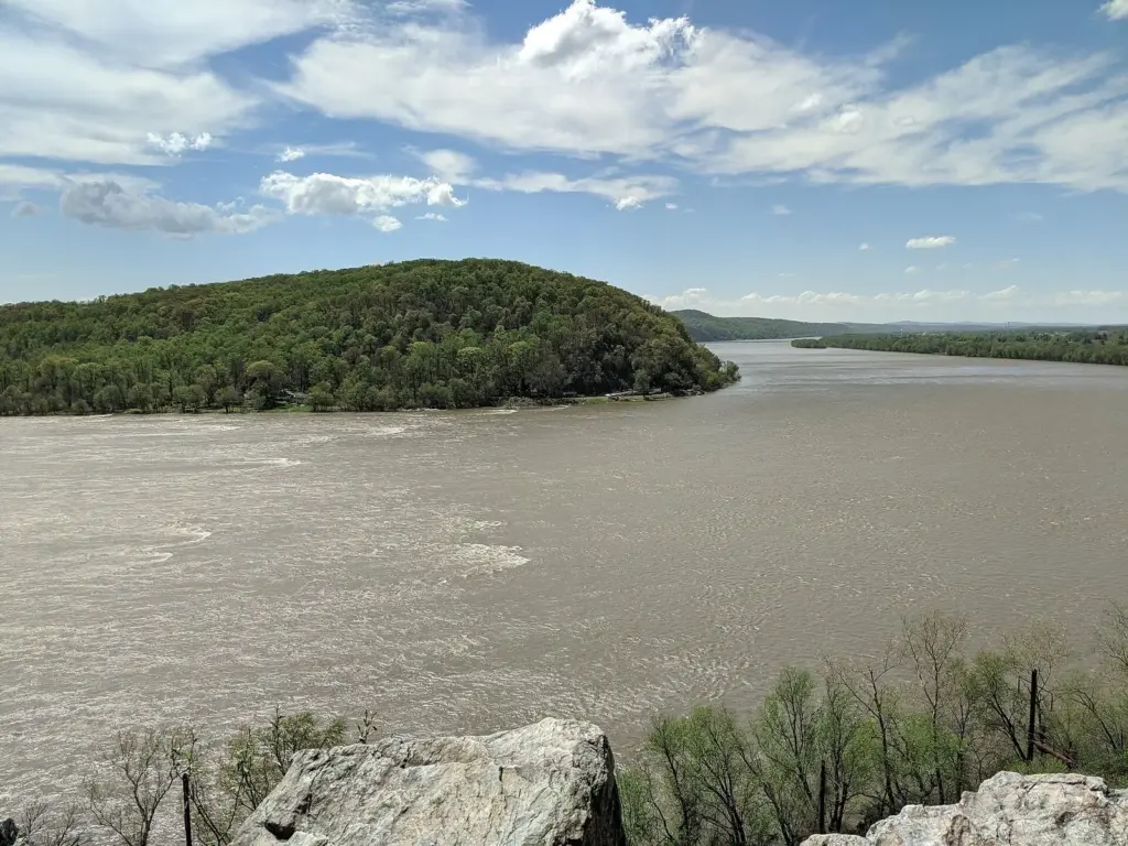The wide Susquehanna River and a wooded bluff seen from the rocks of the Chickies Rock overlook