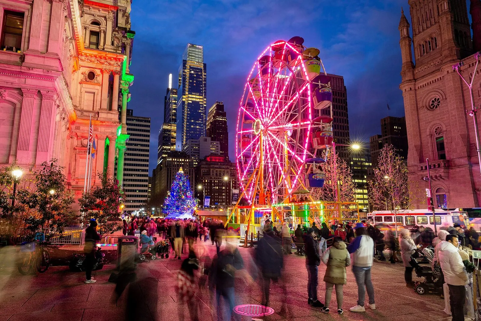 The Ferris wheel and market stalls of Christmas Village at Philadelphia's City Hall at night, one of the best festivals in Pennsylvania