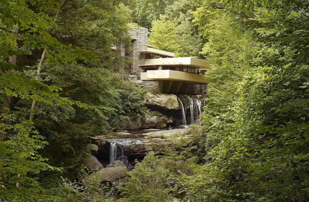 Fallingwater's stacked concrete terraces cantilevered over the Bear Run waterfall in summer