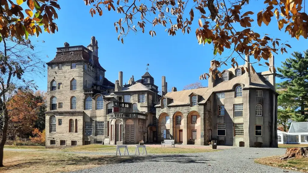 Fonthill Castle's gray concrete towers and roofs framed by autumn leaves