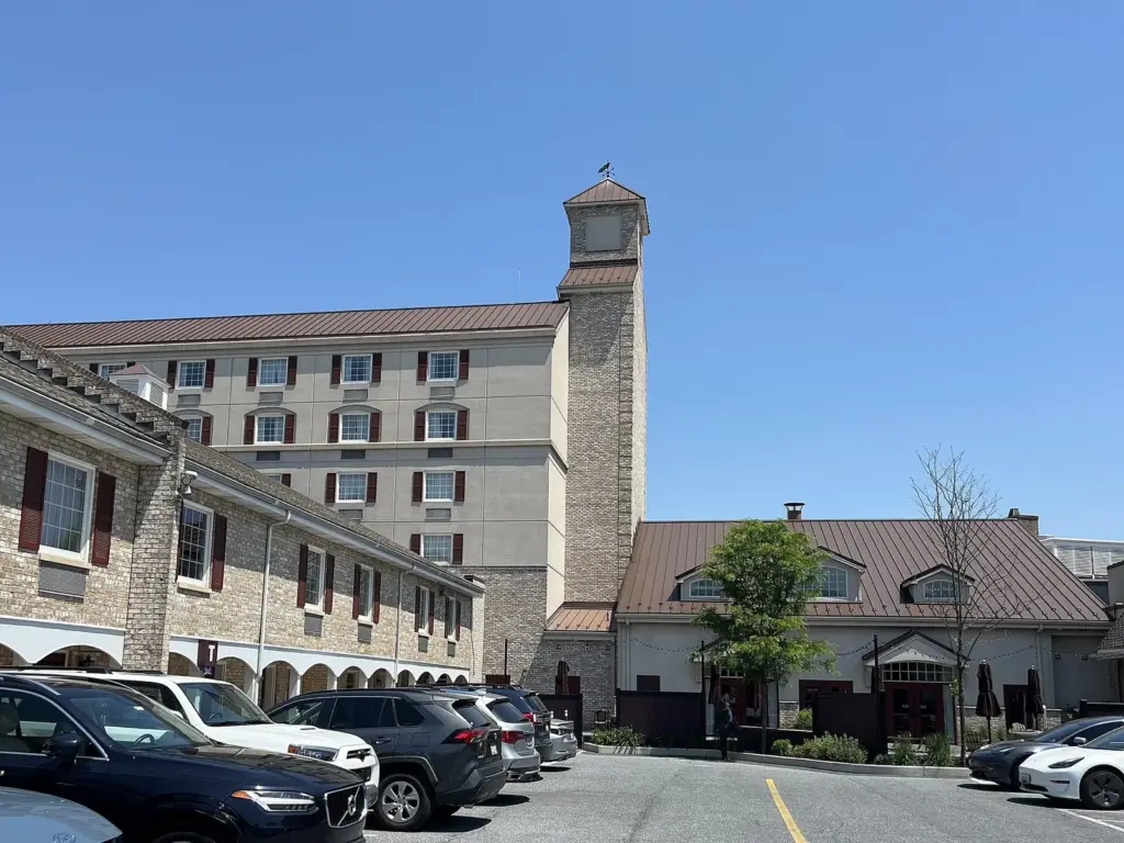 Hershey Lodge's low stone and brick wings beside its tower, with cars in the front lot