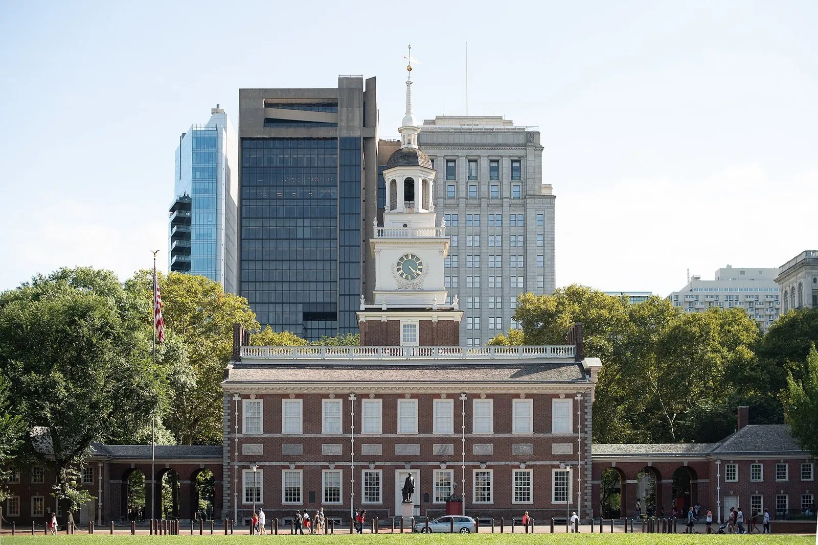 Independence Hall's brick facade and white clock tower at Independence National Historical Park, with office towers behind