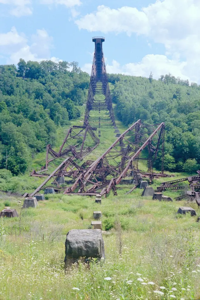 Twisted steel towers of the Kinzua Viaduct lying in the grassy valley below the surviving span