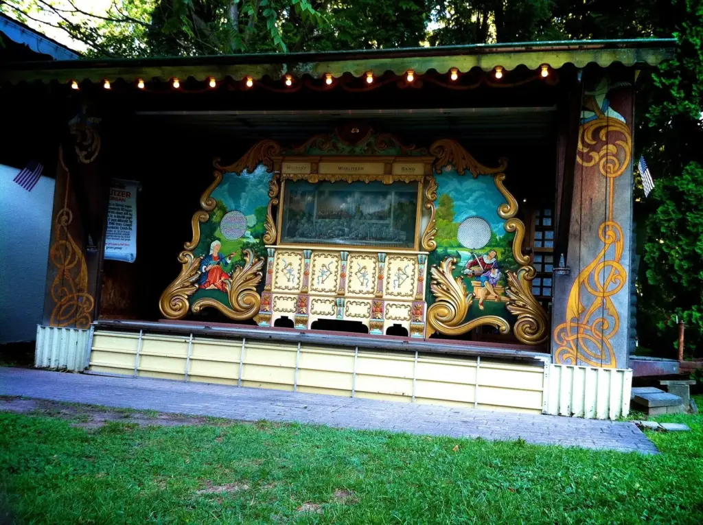 An ornate painted Wurlitzer band organ in a wooden shelter at Knoebels