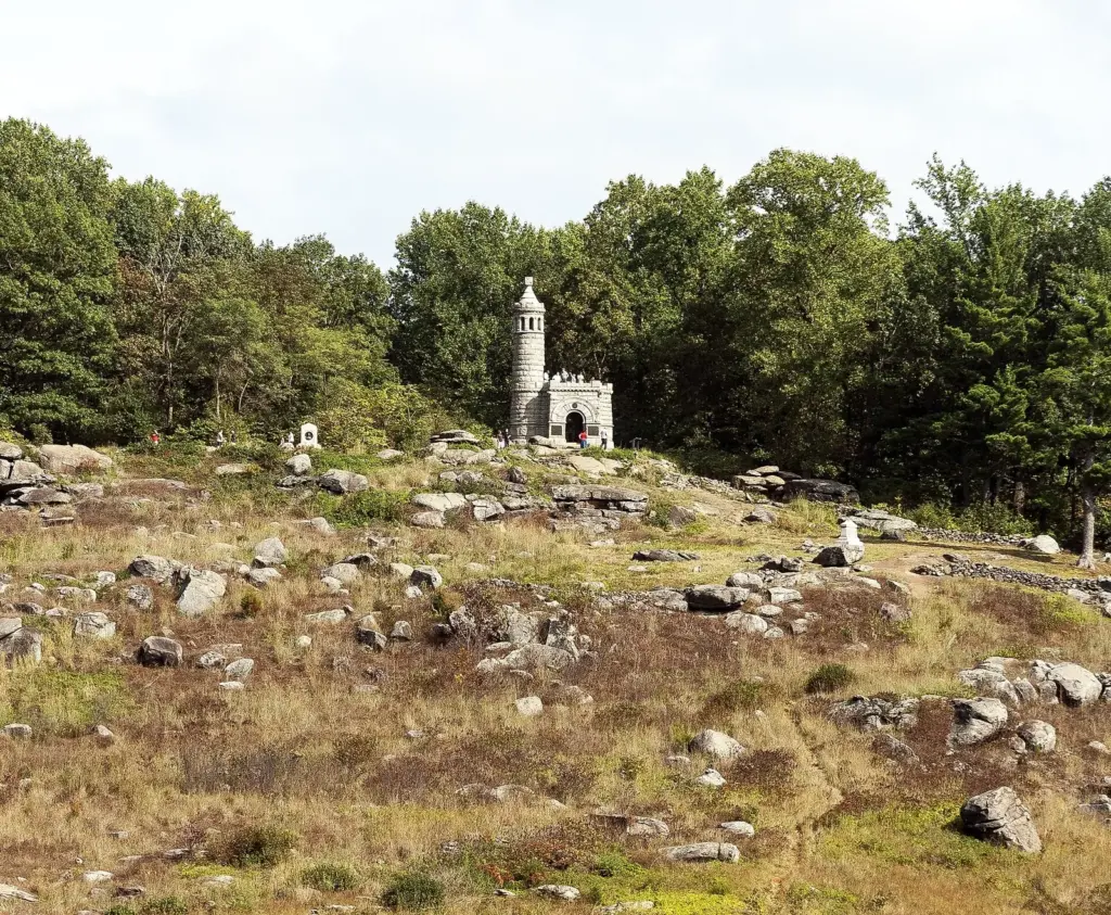 The rocky summit of Little Round Top with the castle-like 44th New York monument among trees
