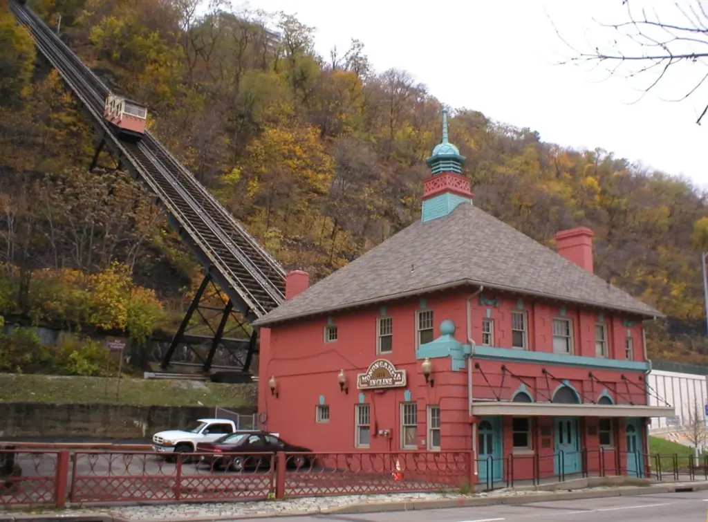 The red-brick lower station of the Monongahela Incline with its track climbing a wooded autumn hillside