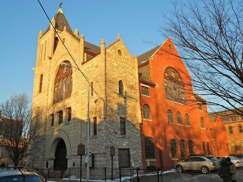 The stone and brick facade of Mother Bethel AME Church glowing in late afternoon light