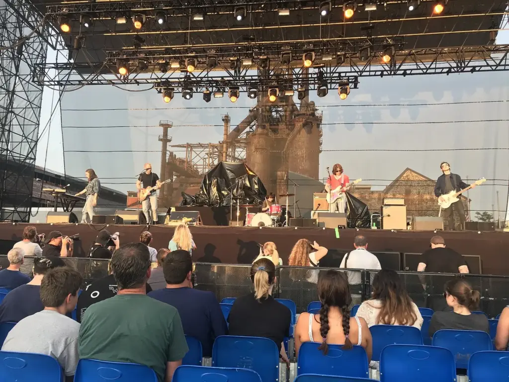 A band playing on an outdoor stage in front of the rusted blast furnaces at SteelStacks in Bethlehem