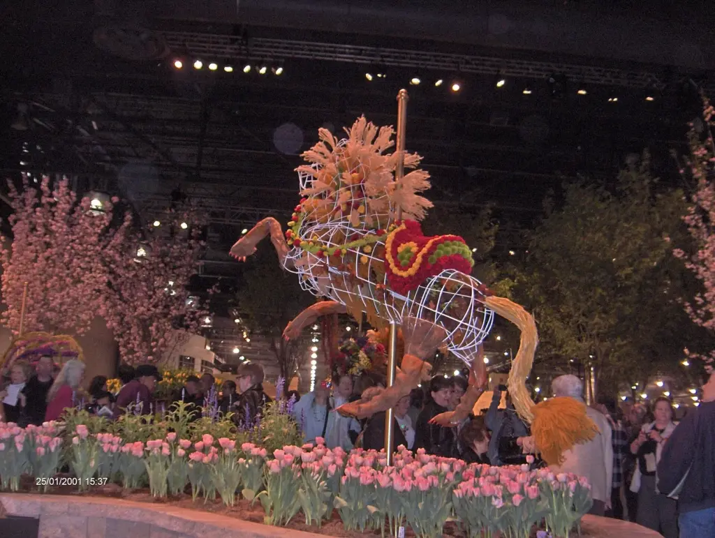 A carousel animal made of dried flowers and grasses above beds of tulips at the Philadelphia Flower Show