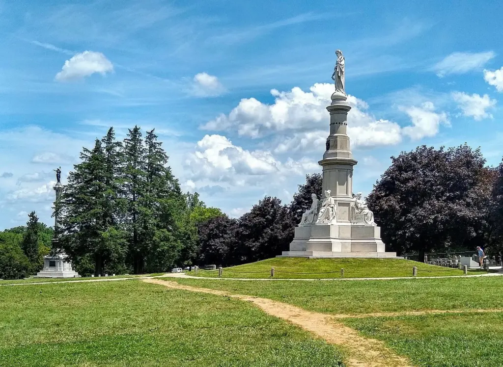 The white Soldiers' National Monument rising above the grass and trees of the Gettysburg National Cemetery