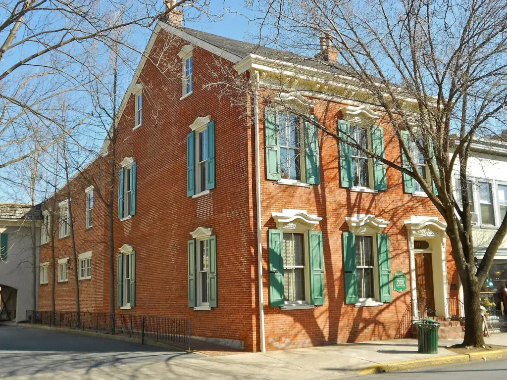 A white 18th-century house with green shutters on East Main Street in Lititz