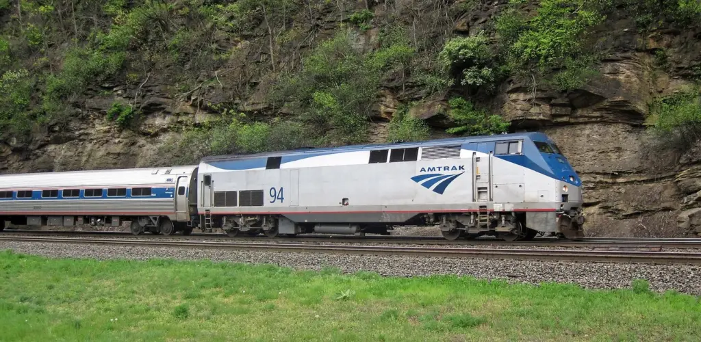 Amtrak's Pennsylvanian rounding Horseshoe Curve below a wooded hillside