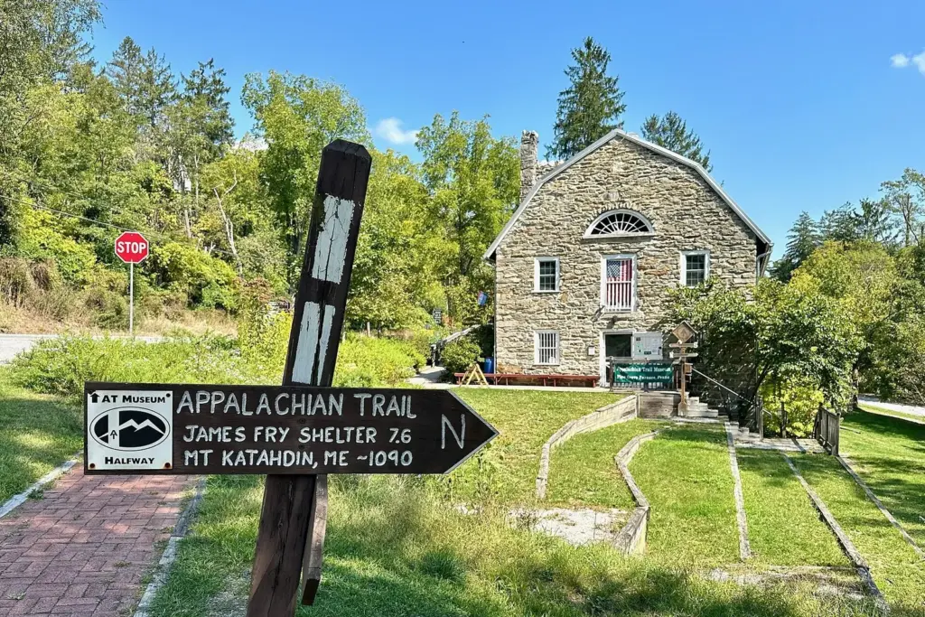 Appalachian Trail signpost beside the stone Appalachian Trail Museum at Pine Grove Furnace