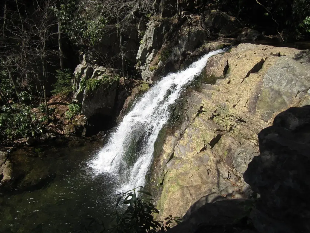 Hawk Falls pouring over a smooth sloping rock face into a pool in Hickory Run State Park