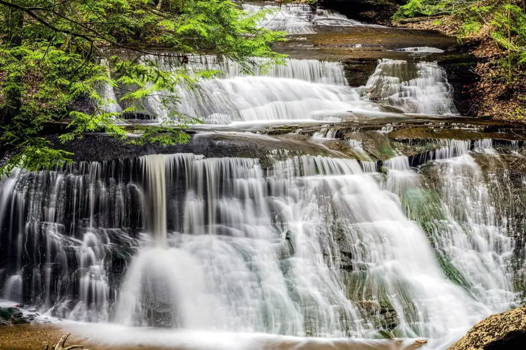 Hells Hollow Falls spreading in many small cascades over layered limestone ledges