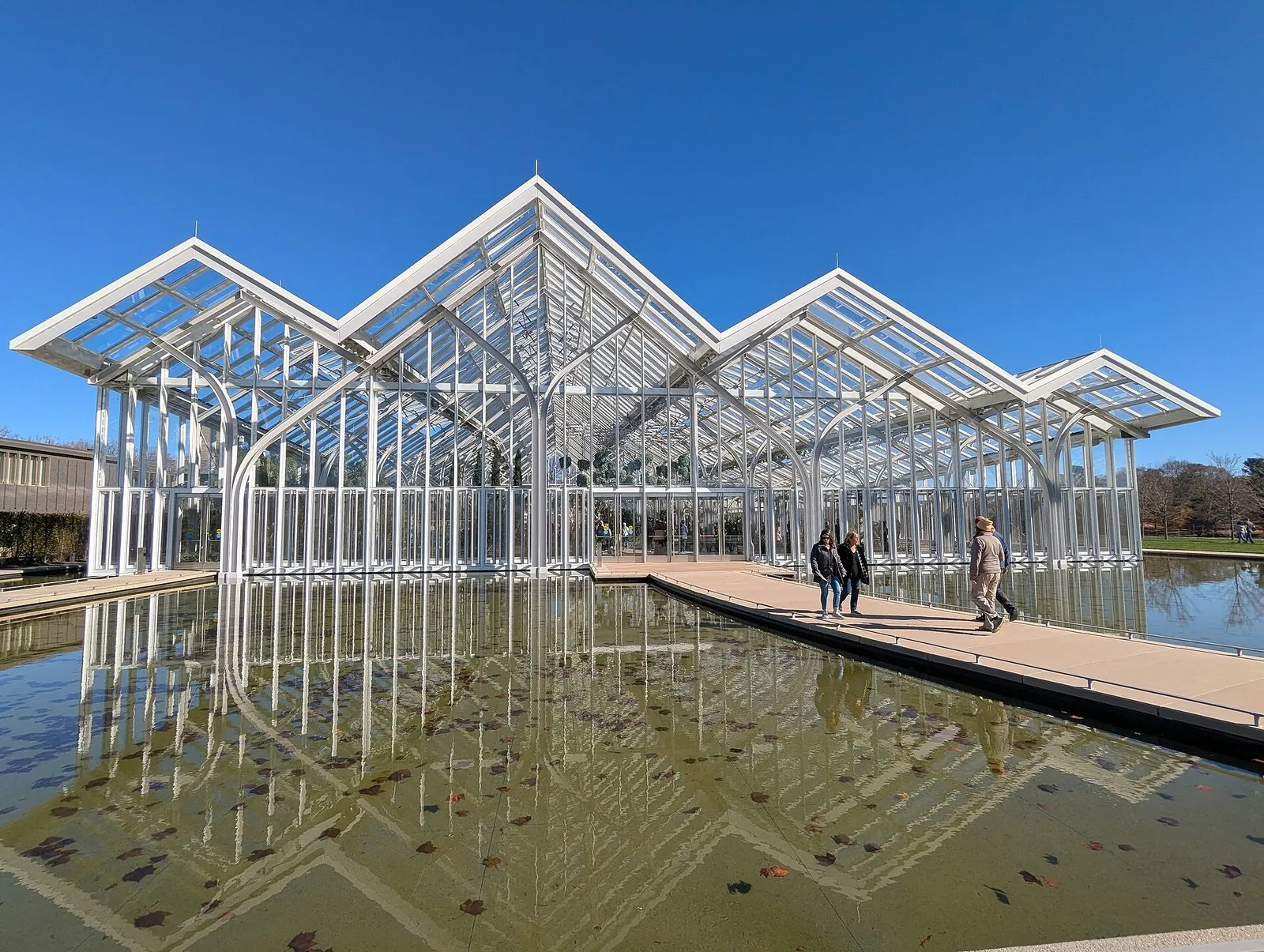 The glass peaks of Longwood Gardens' West Conservatory reflected in a long pool, one of the top things to do in the Brandywine Valley
