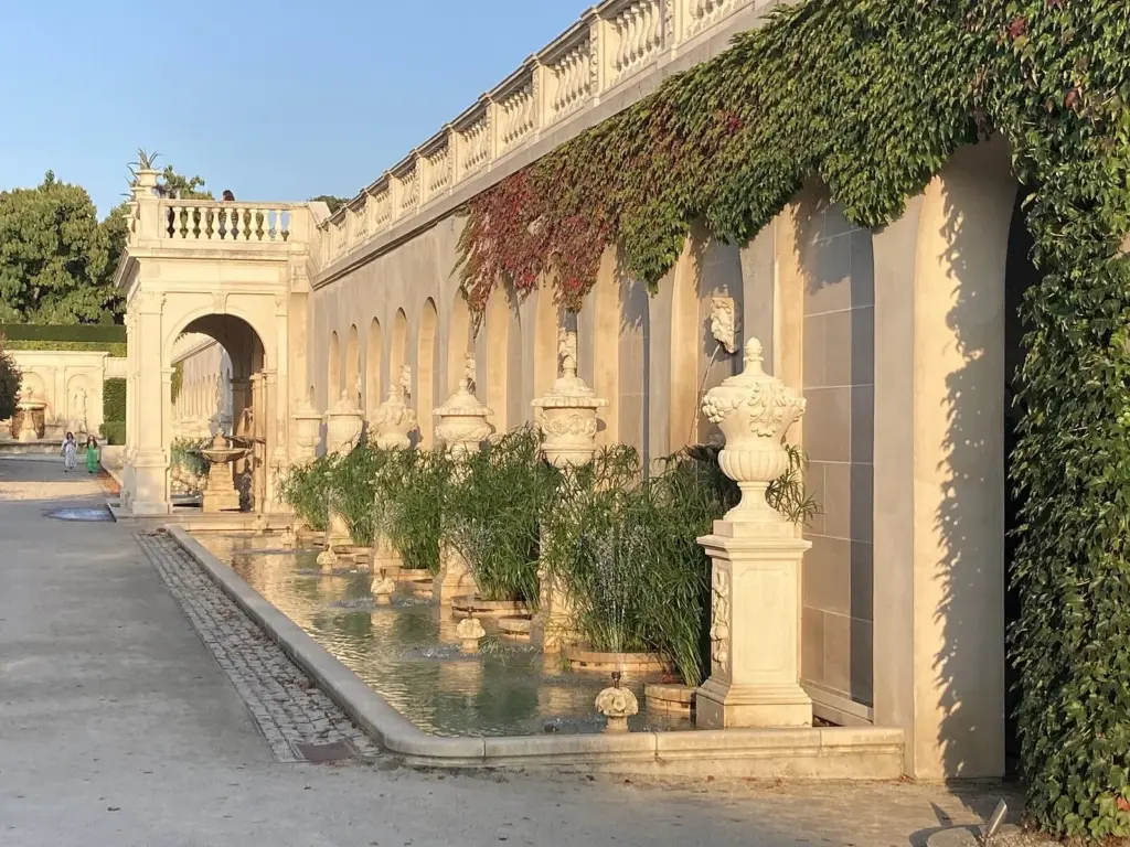Carved stone fountain wall with water basins and ivy in Longwood's Main Fountain Garden