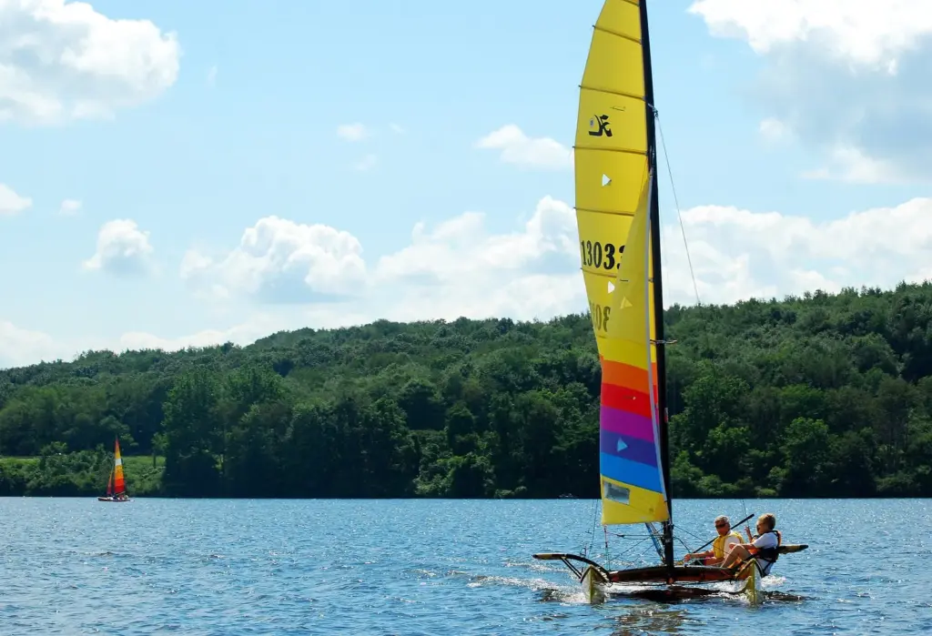 A catamaran with a colorful sail on Lake Arthur at Moraine State Park