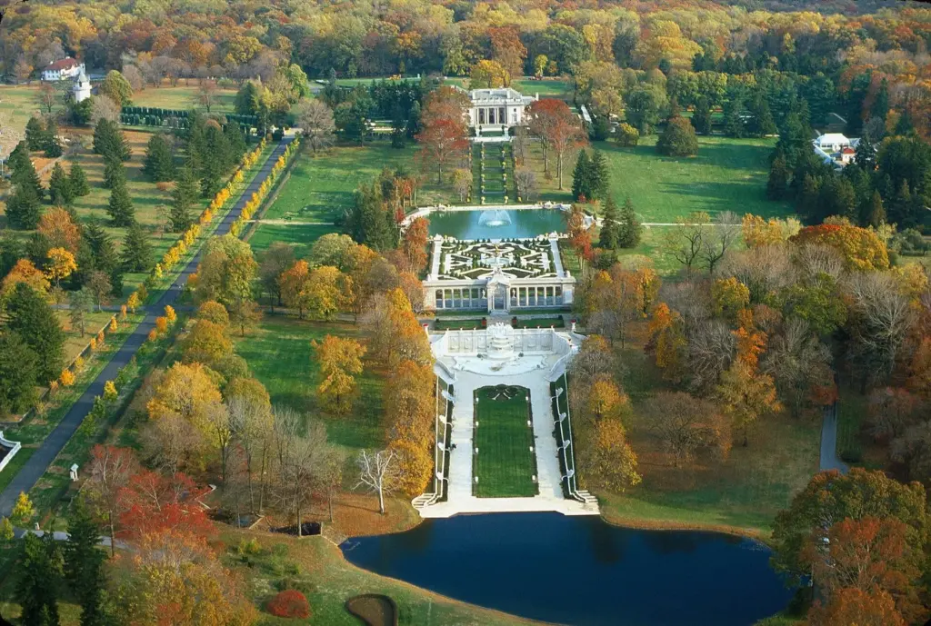 Aerial view of Nemours mansion and its long formal gardens and reflecting pool surrounded by autumn trees