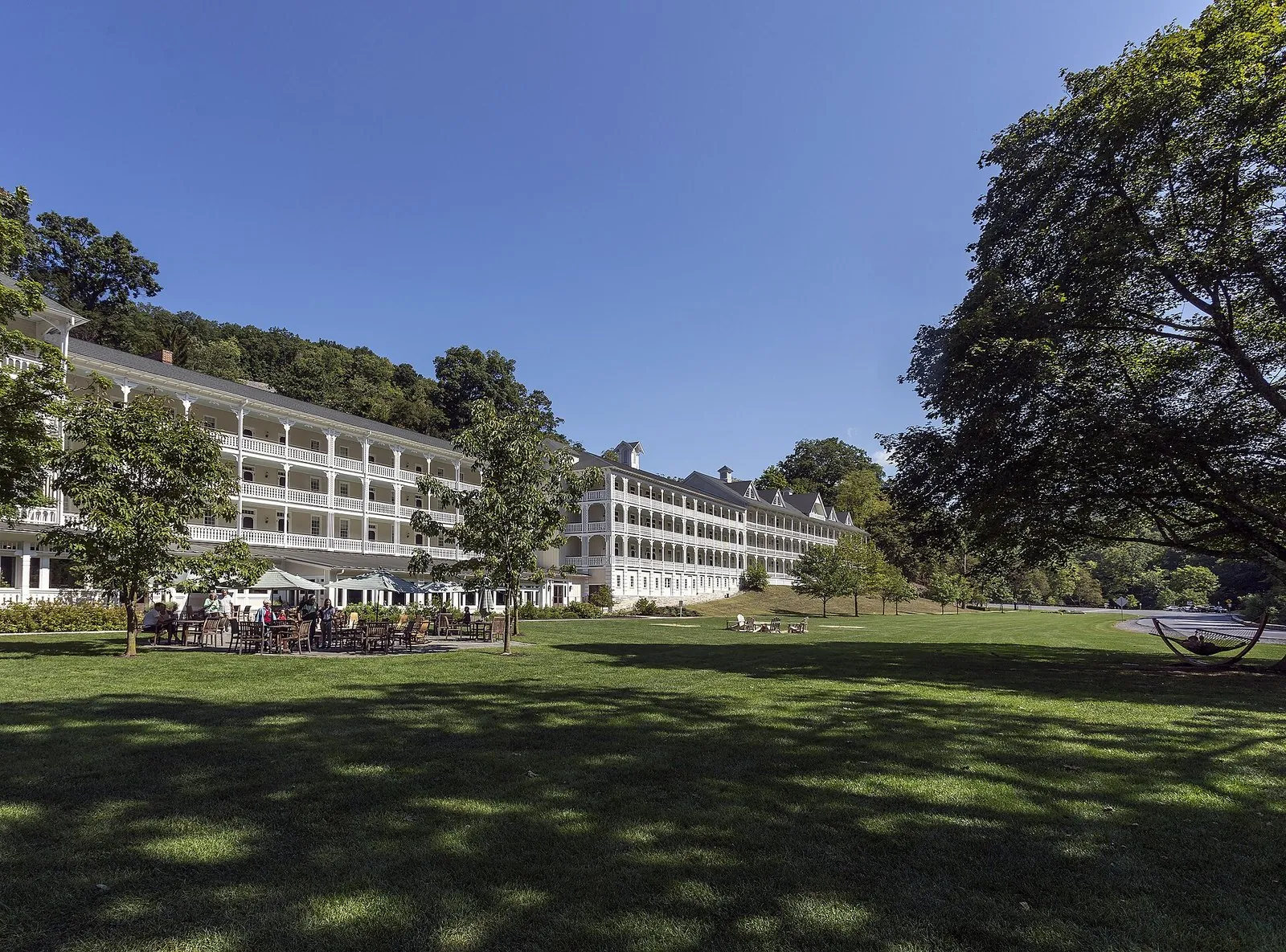 The long white porches of the Omni Bedford Springs Resort behind a wide lawn and old trees, one of the best resorts in Pennsylvania
