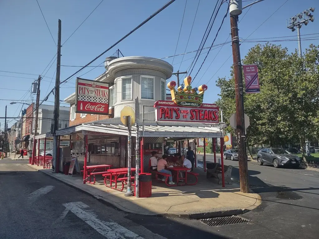 Pat's King of Steaks corner stand with its red awning, outdoor tables and ordering windows in South Philadelphia