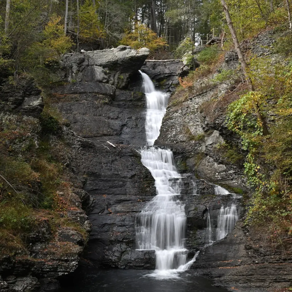 Raymondskill Falls cascading down a narrow rock chute between mossy cliffs