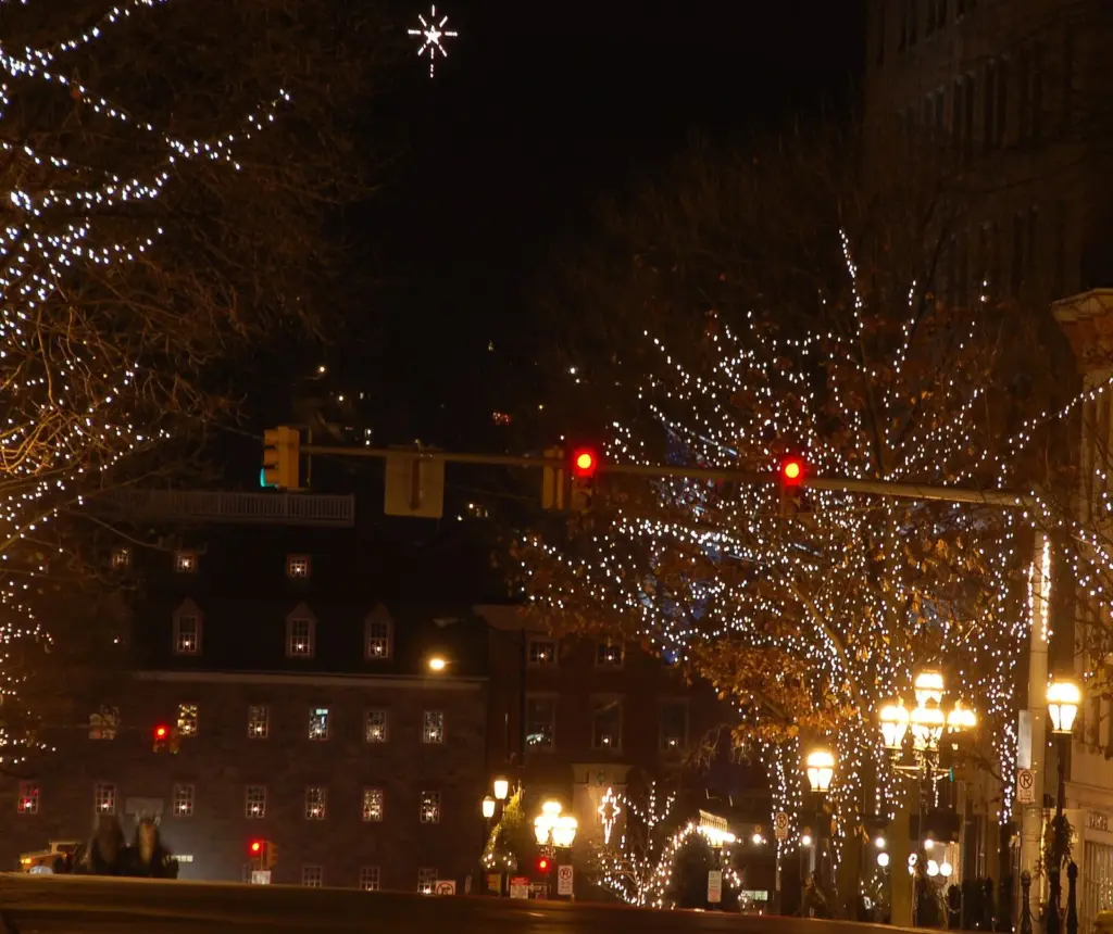 The illuminated Star of Bethlehem glowing above Main Street and its lit trees at night